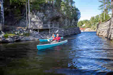 En kvinna och en man paddlar kajak i Lennartsfors