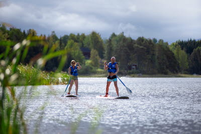 Par paddlar SUP vid Töcksfors camping