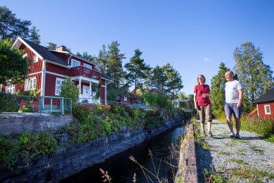 En man och en kvinna vandrar längs med slussen i Lennartsfors