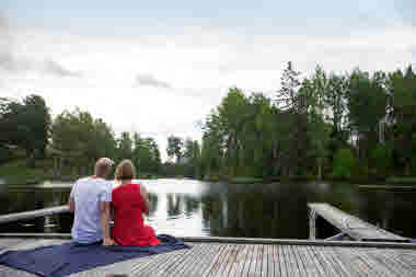 En kvinna och en man har picknick på en brygga i Töcksfors